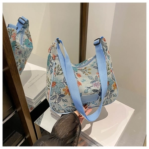Detail of floral printed canvas shoulder bag with adjustable strap and zip closure