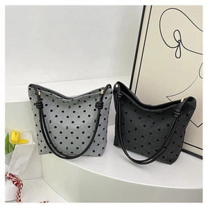 Detailed view of canvas tote bags with polka dot patterns and decorative knot handles