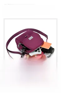 Detail view of purple nylon crossbody bag showing multiple pockets for phone and daily items