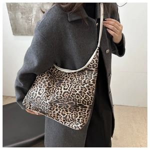 Détail d'un sac cabas à motif léopard avec bordure claire sur un manteau en laine