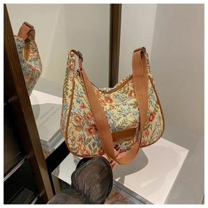 Detailed close-up of a retro floral jacquard hobo bag with brown faux leather trim finish
