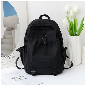 Detail view of black nylon school backpack with drawstring pocket and secure buckles