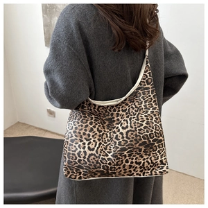 Détail du grand sac cabas imprimé léopard avec passepoil contrasté sur manteau gris