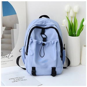 Detail of light blue nylon backpack featuring drawstring front pocket and black buckle