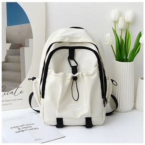 Detailed view of the cream-colored nylon backpack featuring a drawstring front pocket and logo