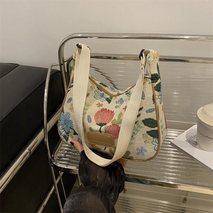 Floral tapestry shoulder bag with vintage woven patterns and wide strap on display