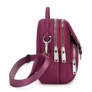 Detailed side view showing three independent zip compartments and nylon fabric of the purple bag