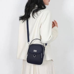 Navy nylon phone crossbody bag shown from a side view on a model with adjustable strap