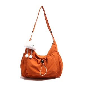 Lightweight orange nylon crossbody bag with drawstring closure and cloud charm