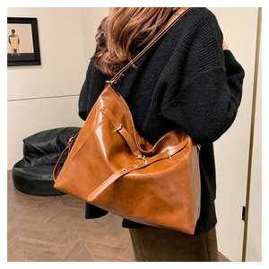 Dettaglio della borsa a spalla vintage marrone caramello con fibbia in metallo regolabile