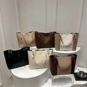 Detail view of large tote bags in various colors with adjustable straps and logo
