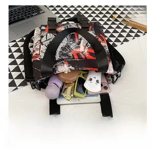 Detail view of graffiti crossbody bag interior showing phone, umbrella and tablet capacity