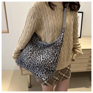 Sac fourre-tout léopard porté avec un pull en maille beige et une jupe à carreaux