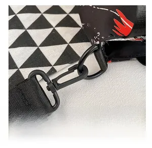 Macro shot of black metal swivel spring hook with thick nylon woven shoulder strap detail