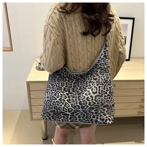 Vue lifestyle d'un grand sac cabas léopard porté avec un pull en maille torsadée