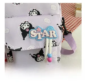 Detailed view of purple canvas bag featuring Kuromi prints and star charm accessory
