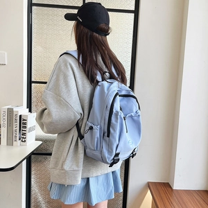Minimalist light blue nylon backpack for school featuring spacious storage and side pockets