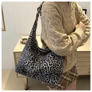 Sac fourre-tout à imprimé léopard porté par un mannequin dans un intérieur chaleureux