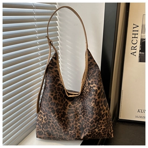 Détail du sac cabas léopard avec anses marrons et boucle de réglage métallique