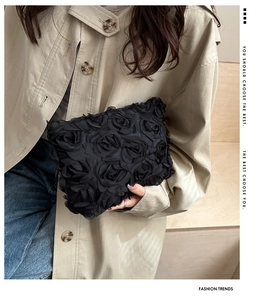 Close-up of elegant black 3D rose textured evening clutch bag with fabric flower details