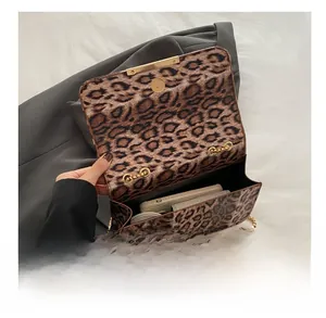 Détail du sac à bandoulière léopard montrant la capacité intérieure pour téléphone et portefeuille