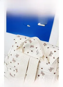 Detail of corduroy backpack with brown floral heart patterns and sturdy top handle