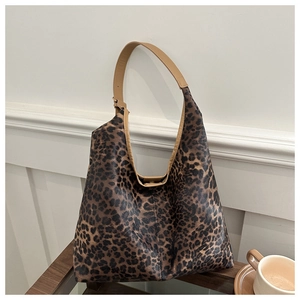 Détail d'un grand sac cabas à imprimé léopard avec des anses en cuir marron et décoratif
