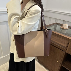 Close-up of stylish large leather tote bag with brown and beige contrast panels