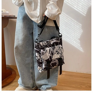 Detail showing graffiti print messenger bag with buckle closure and nylon strap
