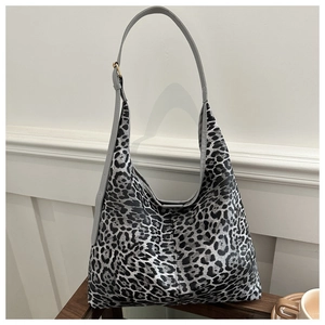 Détail de la bandoulière en cuir gris réglable et texture léopard du sac hobo en toile