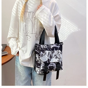 Detail of oxford fabric tote bag with graffiti pattern, dual buckle pockets and strap