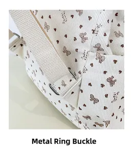 Detail view of the silver metal adjustment buckle and corduroy fabric with butterfly print