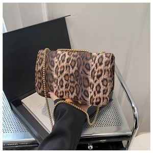 Détail d'un sac à bandoulière léopard en fausse fourrure avec une chaîne dorée