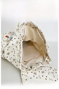 Internal view of corduroy backpack with bow print showing drawstring closure and zip pocket