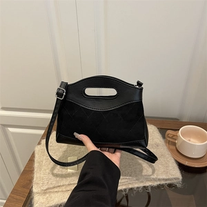 Chic black quilted handbag with oval handle and adjustable strap for women