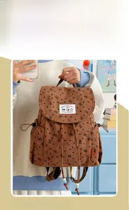 Detailed macro view of brown corduroy backpack with black heart and bow patterns
