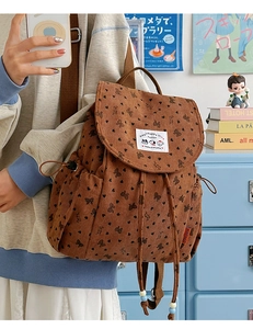 Close-up of brown corduroy backpack with butterfly pattern and drawstring closure