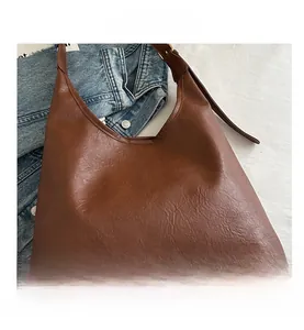 Dettaglio della borsa hobo in pelle PU marrone con grana litchi e silhouette a mezza luna