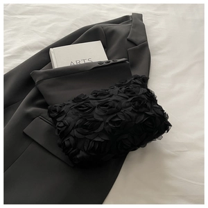 Close-up of black lace clutch bag featuring 3D rose petals and pleated chiffon texture