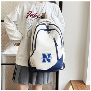 Close-up of a white and blue college-style travel backpack with large N patch detail