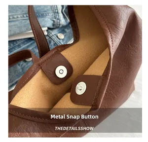 Dettaglio di borsa tote in pelle martellata marrone con chiusura magnetica in metallo sicura