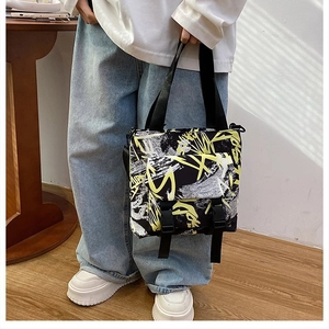 Street style shot of large Oxford cloth tote bag with bold contrast graffiti print
