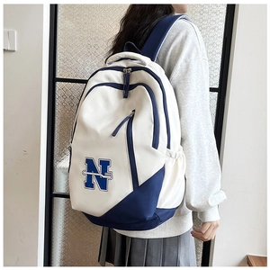 Close-up of stylish white and blue backpack with embroidered N letter and side pockets