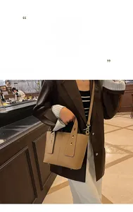 Detailed view of brown lychee grain leather bucket bag with wide strap buckle and gold hardware