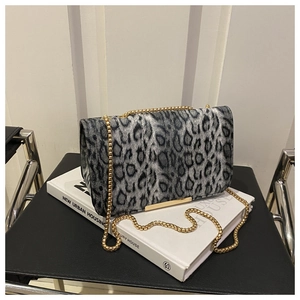 Détail d'un sac léopard avec bandoulière en chaîne dorée et fermoir métallique chic