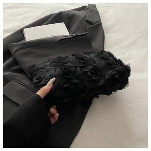 Detail of 3D fabric rose texture on a black evening clutch bag for formal occasions