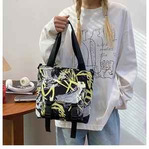 Macro view of street style graffiti oxford tote bag featuring contrast color side buckles