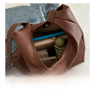 Vista interna della grande borsa tote marrone che mostra spazio per ombrello e libri