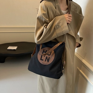 Minimalist canvas tote bag with brown leather handles and HU LN logo patch for women