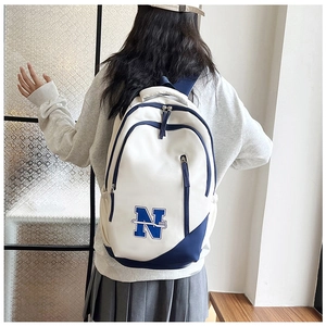 Student wearing a large white and blue canvas backpack with N embroidery on back